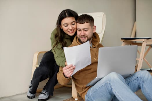 Man and woman smiling while looking at a laptop